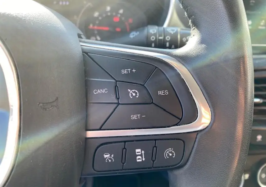 Gros plan sur les commandes de régulateur de vitesse au volant en cuir noir du Fiat Tipo 2018.
