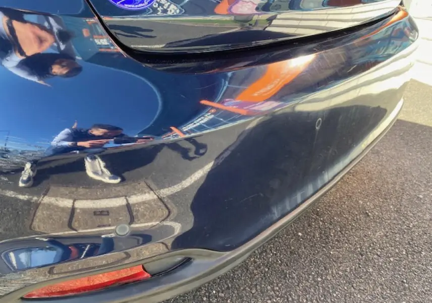 Détail du pare-chocs arrière bleu métallisé du Fiat Tipo 2018 avec capteur de recul visible.