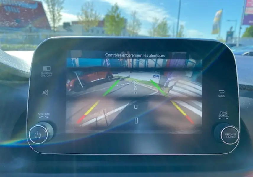 Écran tactile du système multimédia Uconnect affichant la caméra de recul dans un FIAT Tipo bleu, vue intérieure frontale.