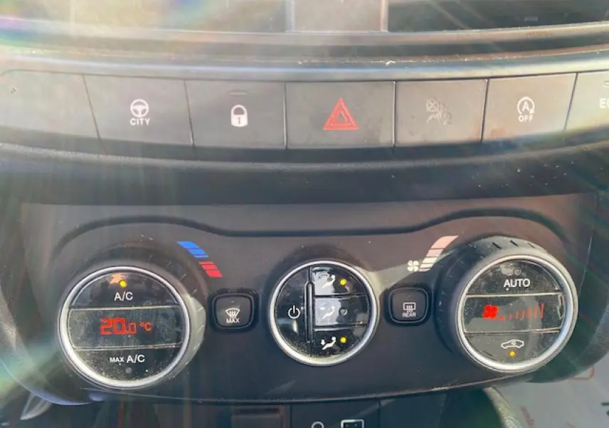 Gros plan sur les commandes de climatisation du tableau de bord d'une Fiat Tipo 2018, éclairage naturel.