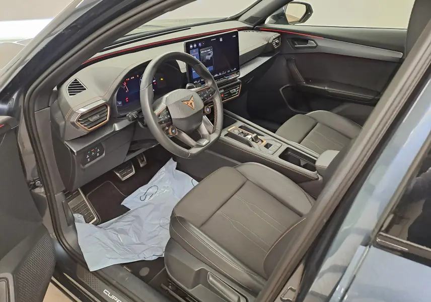 Intérieur vue côté conducteur du CUPRA Formentor gris magnétique, volant cuir, écran tactile et finitions cuivrées visibles.