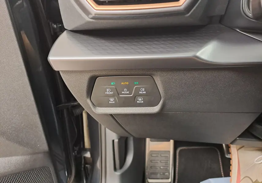 Gros plan sur les commandes d'éclairage à gauche du volant dans l'habitacle gris du CUPRA Formentor 2025.