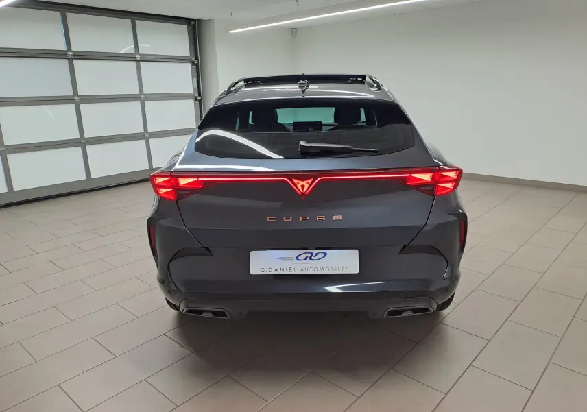 Vue arrière d'un CUPRA Formentor gris magnétique avec bandeau lumineux Tri-LED et double sortie d'échappement noire.