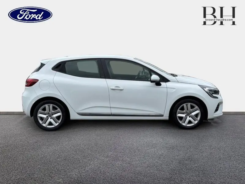 Profil droit d'une Renault Clio blanche 2021, avec jantes alliage et poignées ton carrosserie visibles.
