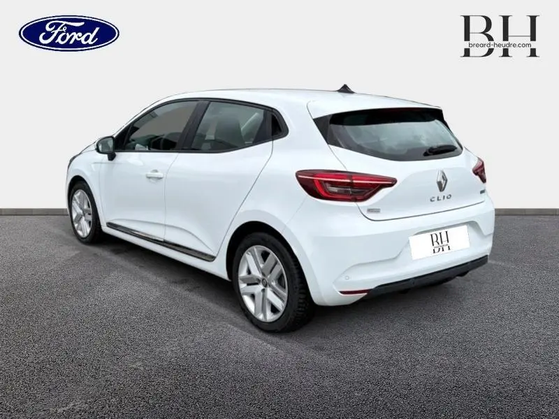Renault Clio blanche vue 3/4 arrière droit, avec feux arrière LED et becquet noir sur toit.