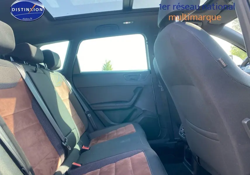 Vue intérieure arrière côté droit du SEAT Ateca gris 2020, montrant les sièges en alcantara brun et toit panoramique.