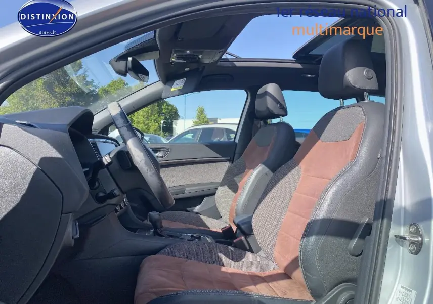 Vue intérieure côté gauche du SEAT Ateca gris 2020, mettant en valeur les sièges sport en alcantara brun et toit panoramique ouvert.