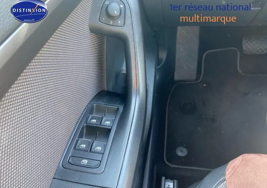 Vue rapprochée du panneau de commandes des vitres côté conducteur d’un SEAT Ateca gris avec tissu brun et alcantara.