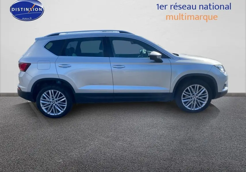 Vue latérale droite d'un SEAT Ateca gris 2020 avec jantes alliage et rétroviseurs argentés sur fond neutre.