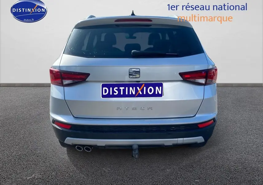 Vue arrière d'un SEAT Ateca gris 2020 avec double sortie d'échappement et attelage visible.