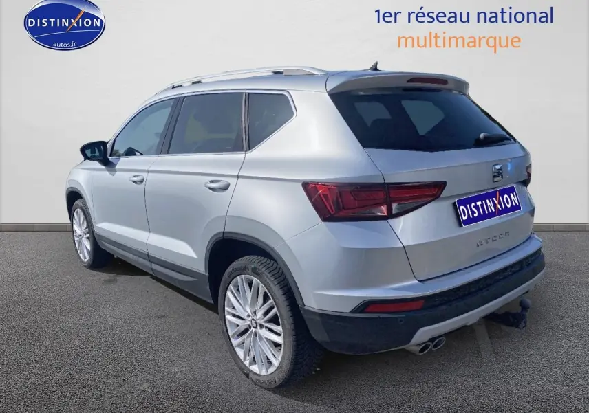 Vue 3/4 arrière droite d'un SEAT Ateca gris 2020 avec jantes alu et double sortie d'échappement chromée.