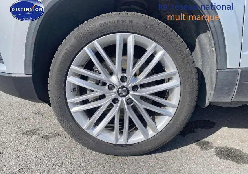 Gros plan sur la roue avant gauche grise d'une SEAT Ateca 2.0 TDI 150 Xcellence avec jante alu multibranches.