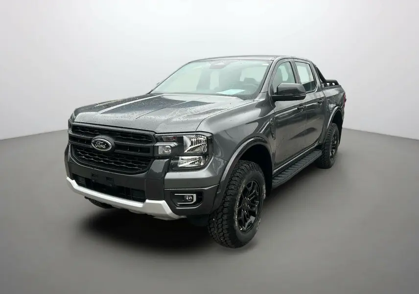 Ford Ranger gris carbone en 3/4 avant droit avec arceaux noirs et marchepieds visibles sur fond neutre.