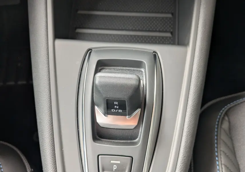Gros plan sur la commande de boîte automatique noire et grise au centre de la console intérieure du Renault Symbioz gris Rafale Métal.