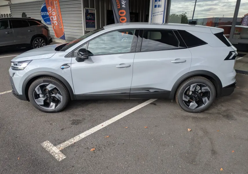 Vue latérale droite du Renault Symbioz gris rafale métal, soulignant ses jantes bicolores et lignes modernes.