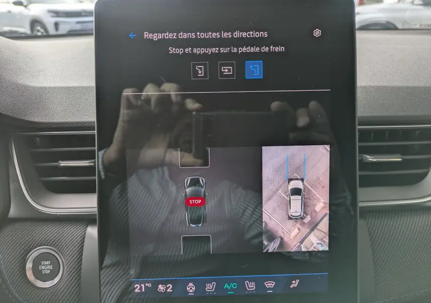 Écran tactile central du Renault Symbioz 2026 affichant l'aide au stationnement avec vue aérienne et instructions de freinage.