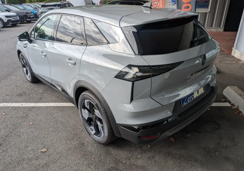 Vue 3/4 arrière droite d'une Renault Symbioz gris rafale métal avec vitres teintées et jantes bi-ton.