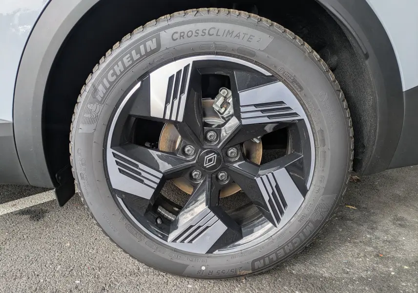 Gros plan sur la roue avant droite de la Renault Symbioz gris Rafale métal, jante noire et argentée au design géométrique.