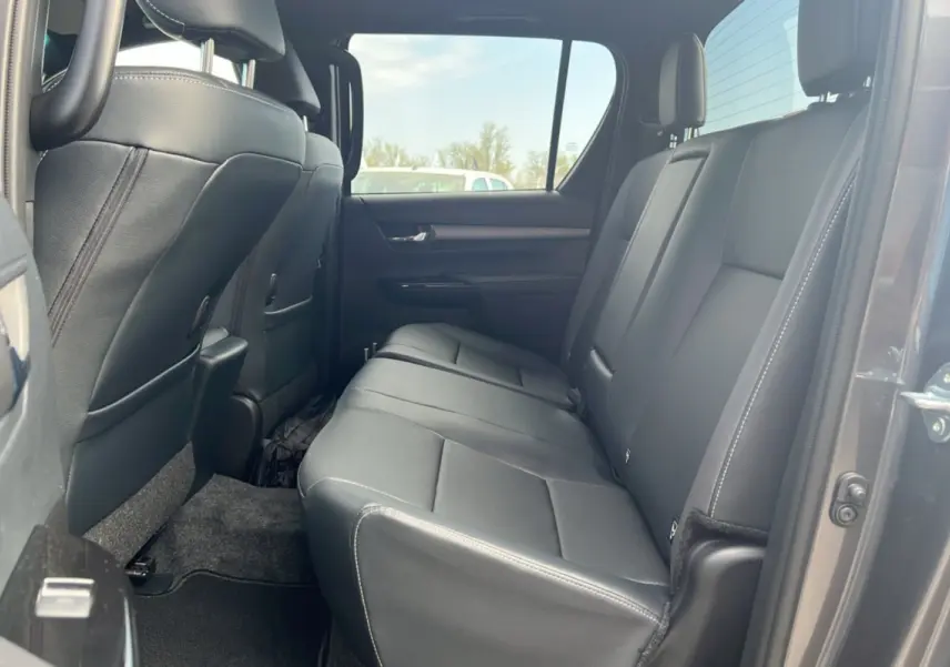 Vue intérieure côté droit sur la banquette arrière en cuir noir du Toyota Hilux 4x4 gris atlas 2025 Invincible.