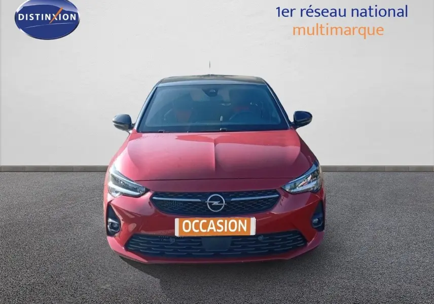 Vue de face d'une Opel Corsa 1.2 Turbo rouge métal avec toit noir, calandre et phares LED distinctifs.