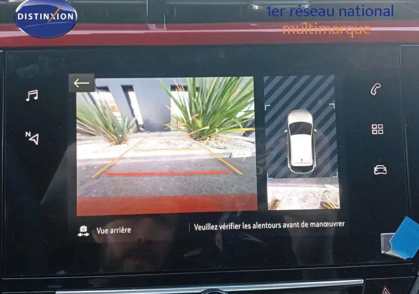 Écran multimédia affichant la caméra de recul et la vue 360° d’une Opel Corsa rouge métal avec toit noir.