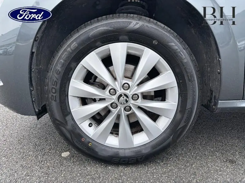Gros plan sur la roue avant gauche gris Météore d'un Skoda Kamiq 1.0 TSI 95ch Business avec jante alu.