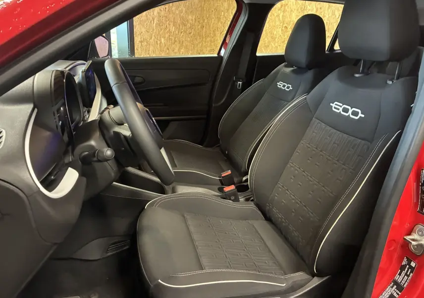 Vue intérieure côté gauche de la FIAT 600 1.2 Hybrid 2024 rouge, sièges noirs avec logo 600 brodé en blanc.