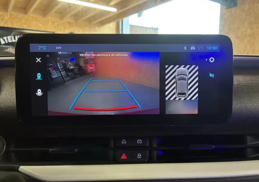 Écran central de la FIAT 600 rouge 2024 montrant la caméra de recul avec guidage de trajectoire en intérieur.