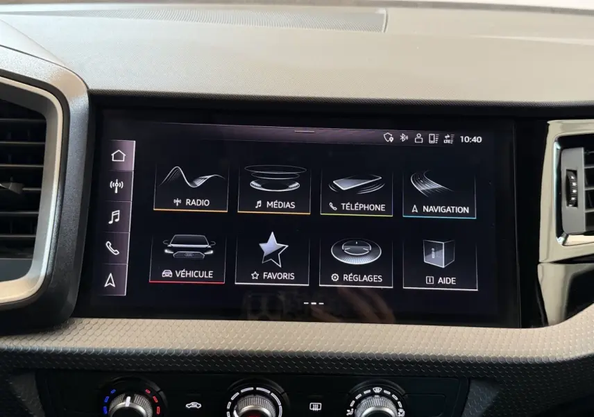 Écran tactile central de l’Audi A1 2021 affichant les menus radio, médias, téléphone et navigation, tableau de bord noir.