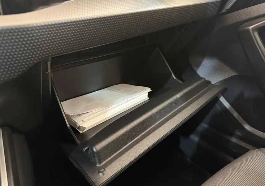 Vue intérieure du vide-poche passager ouvert de l'Audi A1 Business Line 2021, avec documents visibles à l'intérieur.