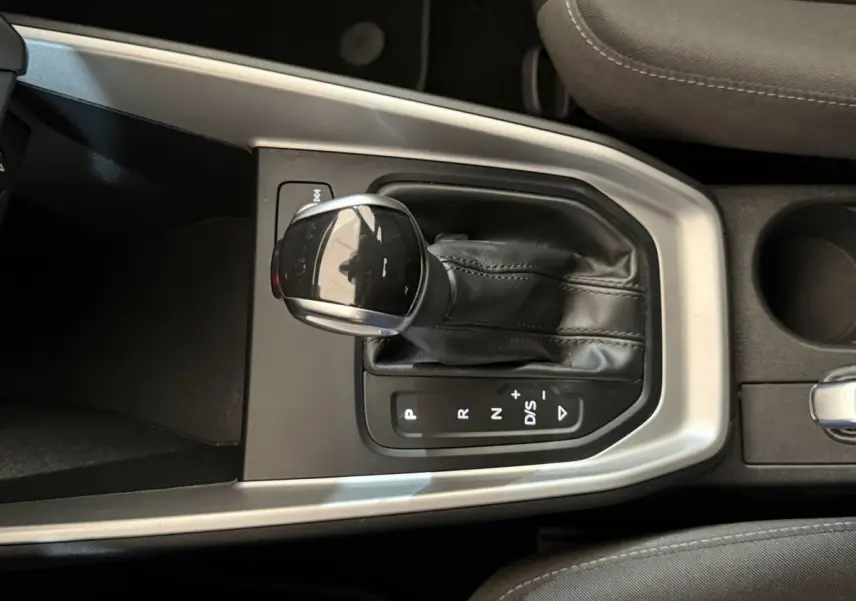 Le levier de vitesses automatique noir de l'Audi A1 2021 vu de dessus, entouré de garniture argentée.