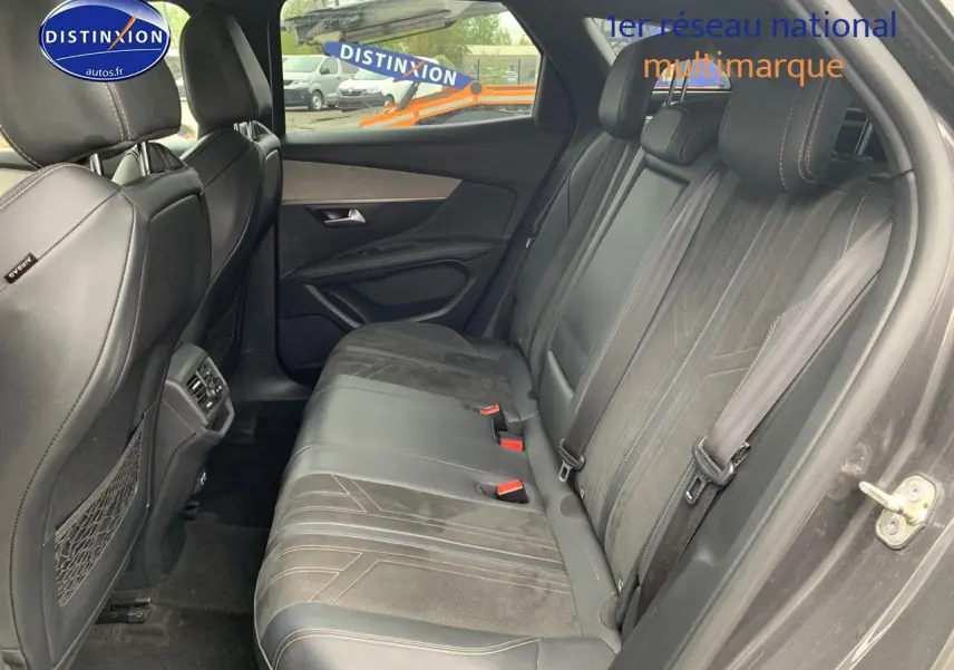 Vue intérieure côté droit montrant la banquette arrière en cuir noir avec surpiqûres du Peugeot 3008 gris platinium.
