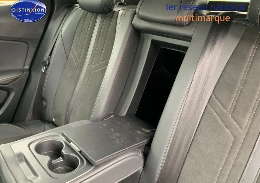 Intérieur arrière du Peugeot 3008 gris platinium, vue sur les sièges noirs avec accoudoir central et porte-gobelets.