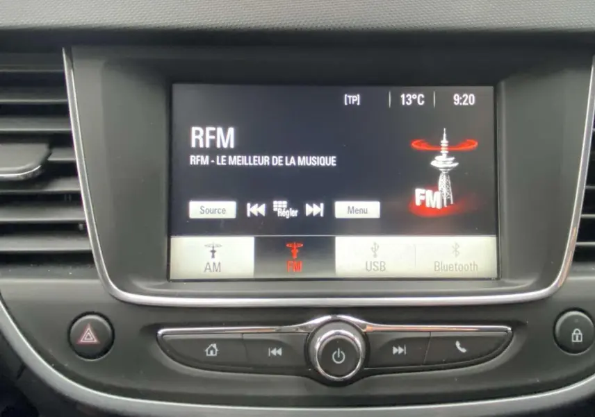 Écran central de l’Opel Crossland X 2020 affichant la radio FM RFM, avec commandes et tableau de bord en noir.
