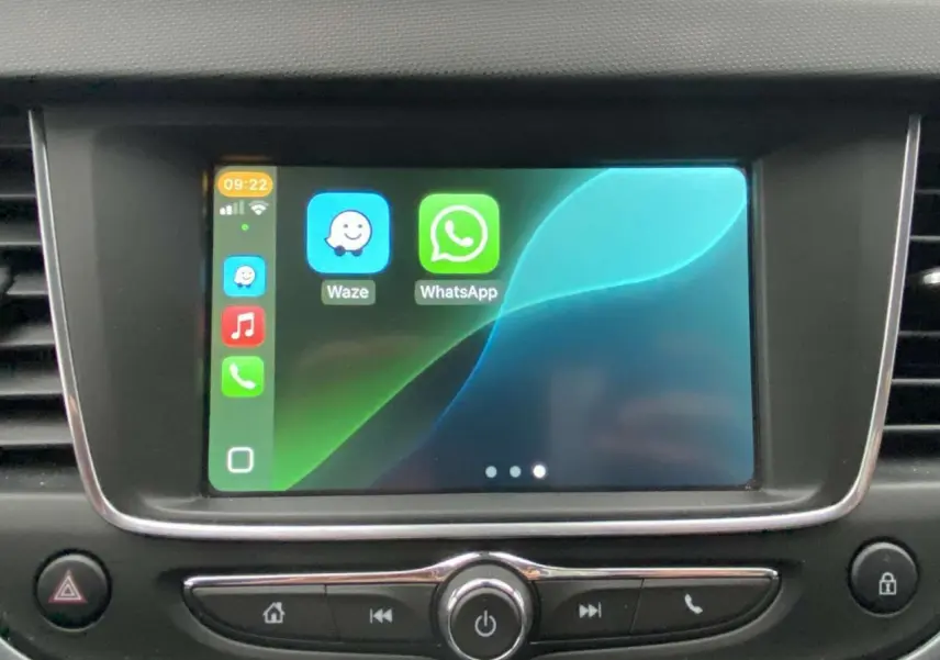 Écran tactile central de l’Opel Crossland X 2020 affichant les applications Waze et WhatsApp, entouré de commandes noires.