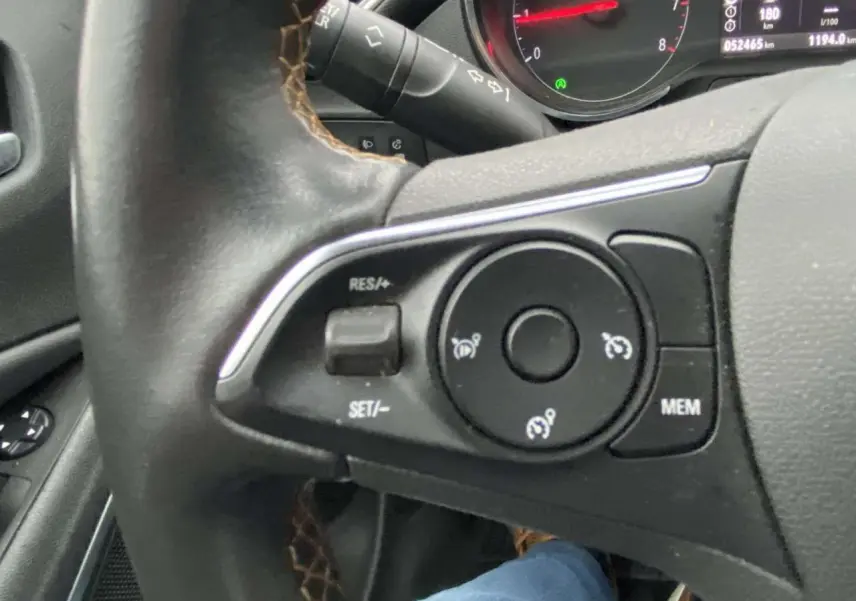 Gros plan sur le volant noir de l'Opel Crossland X 2020, montrant les commandes de régulateur de vitesse et le tableau de bord partiel.