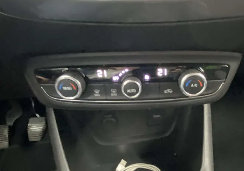Gros plan sur la console centrale de l'Opel Crossland X 2020, montrant les commandes de climatisation digitales.
