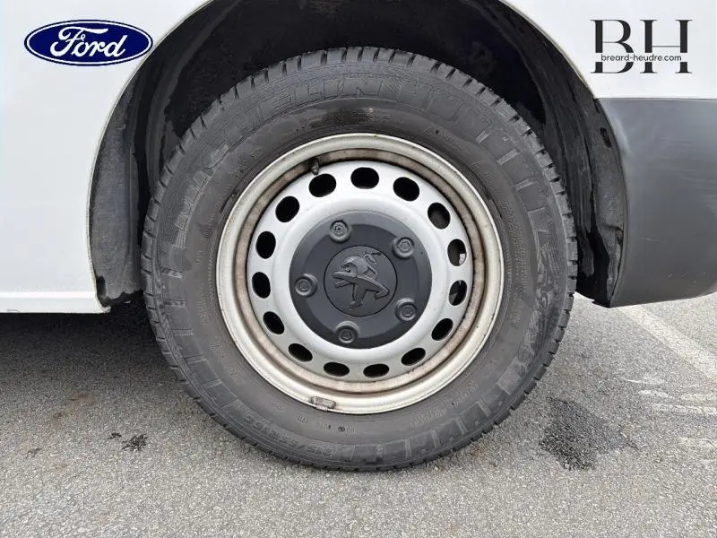Gros plan sur la roue avant gauche du Peugeot Expert Fourgon blanc Banquise, avec jante acier et logo lion central.