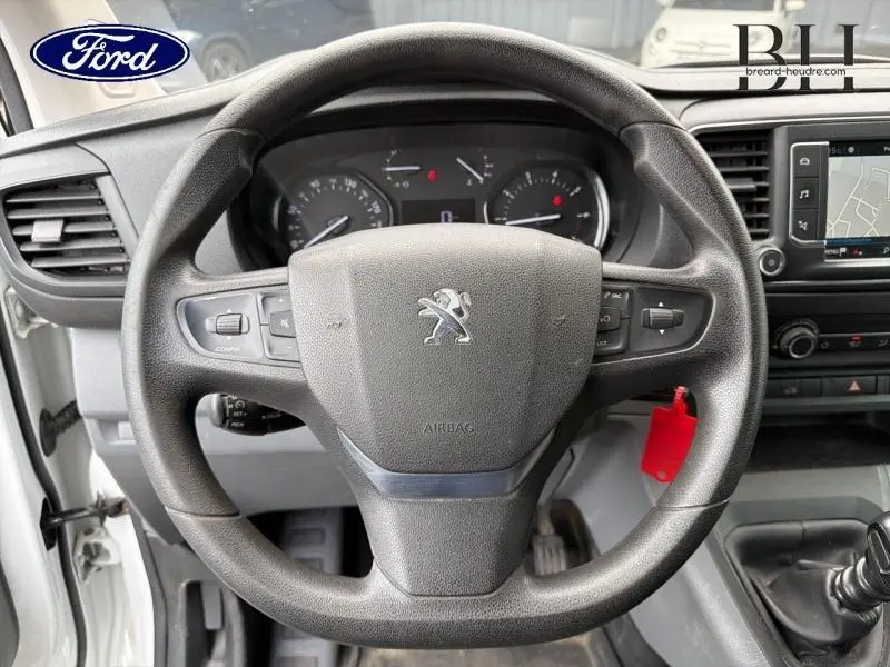 Vue rapprochée du volant Peugeot noir avec tableau de bord et écran tactile du Peugeot Expert Fourgon blanc Banquise.