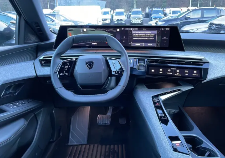 Intérieur Peugeot 5008 Hybrid 145 Allure Plus vu de face, volant cuir, écran incurvé 21 pouces et console centrale grise.