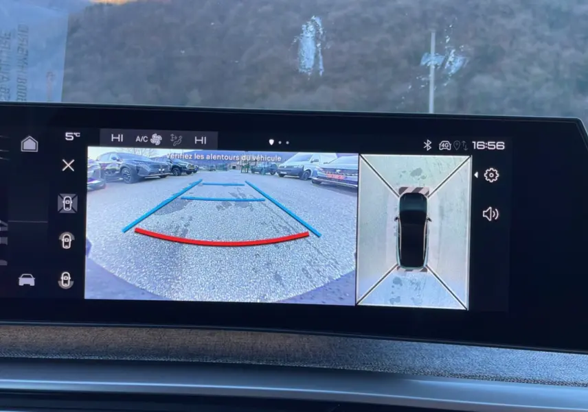 Écran de caméra 360° et recul affichant l'environnement autour du Peugeot 5008 gris titane en stationnement.
