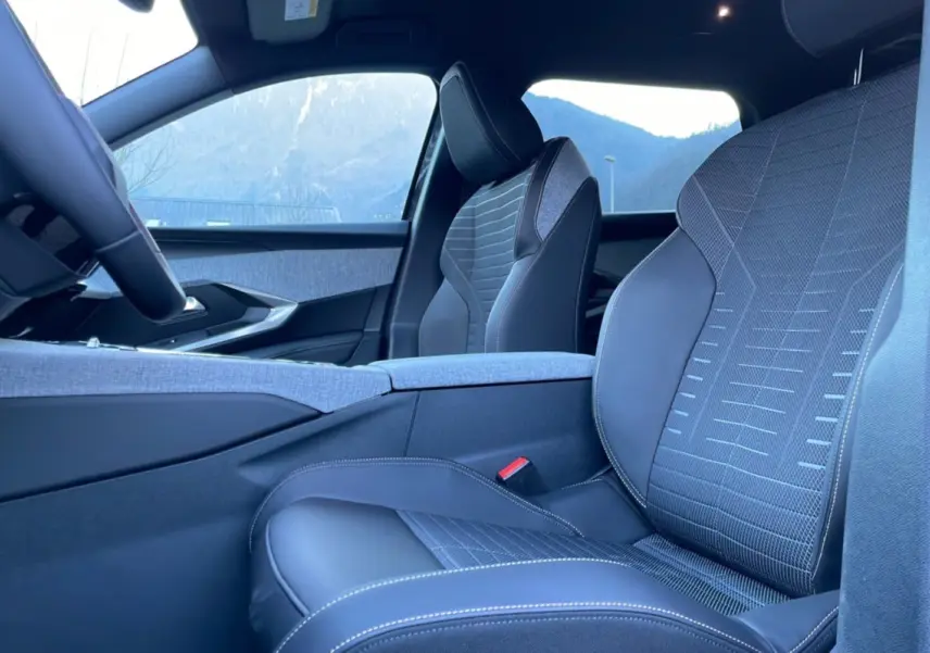 Vue intérieure côté conducteur du Peugeot 5008 Hybrid 145 Allure Plus, sièges cuir tissu gris avec surpiqûres blanches.