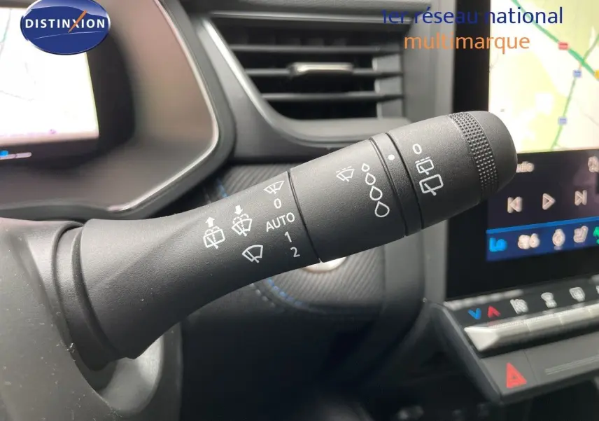 Gros plan sur la commande des essuie-glaces dans l’habitacle noir du Renault Symbioz gris Rafale, avec écran tactile en arrière-plan.