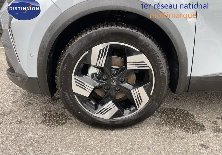 Gros plan sur la roue avant droite du Renault Symbioz gris Rafale métal, mettant en valeur la jante noire et argentée au design moderne.