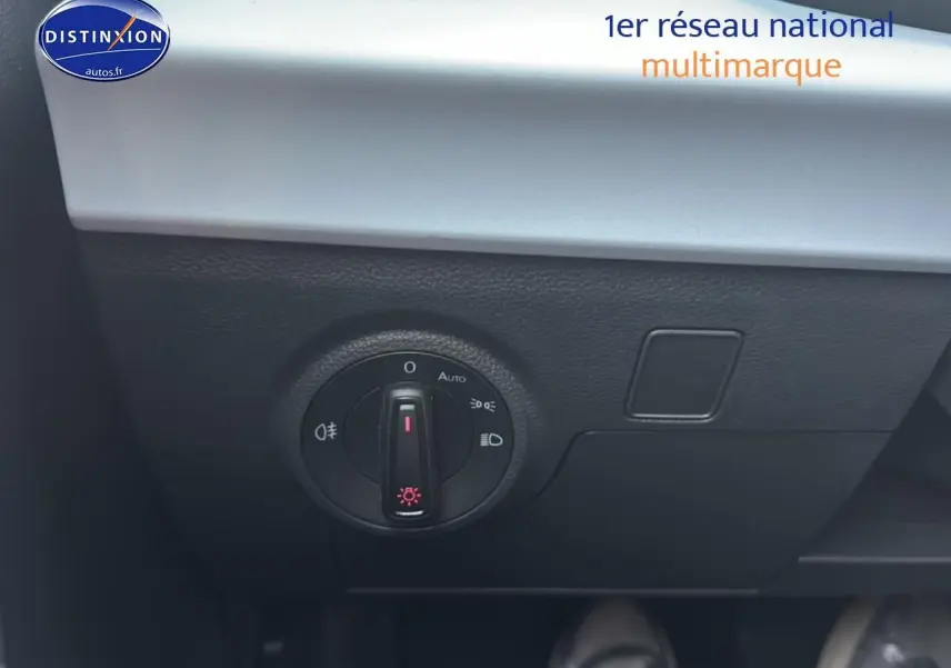 Gros plan sur le bouton de commande des phares dans l’habitacle du SEAT Arona bleu saphir 2025.