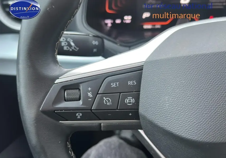 Gros plan sur le volant cuir noir multifonction du SEAT Arona 2025 avec commandes de régulateur de vitesse visibles.