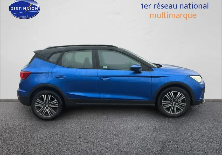 Vue de profil côté gauche d'un SEAT Arona bleu saphir avec toit noir et jantes 17 pouces urban design.