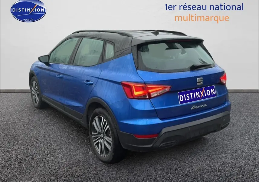 Vue 3/4 arrière droite d'un SEAT Arona bleu saphir avec toit noir et jantes 17 pouces urban design.