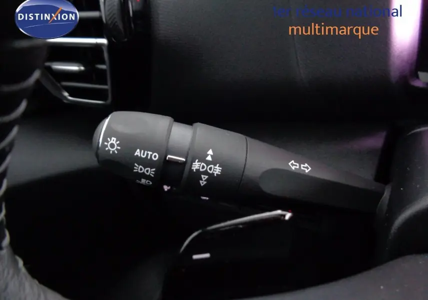 Gros plan sur la commande des feux et clignotants dans l’habitacle noir d’une Citroën C4 Gris Artense 2023.