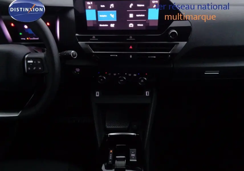 Intérieur de la Citroën C4 2023 en gris, vue centrée sur la console avec écran tactile et levier de boîte automatique.
